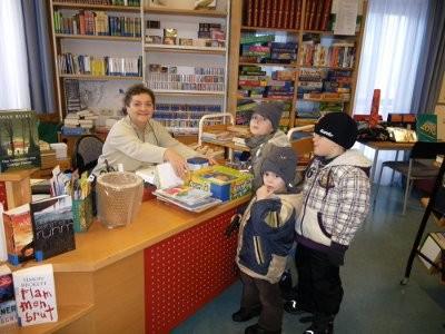 Eingangsbereich mit Bibliothekarin und Kindern vor ihrem Schreibtisch