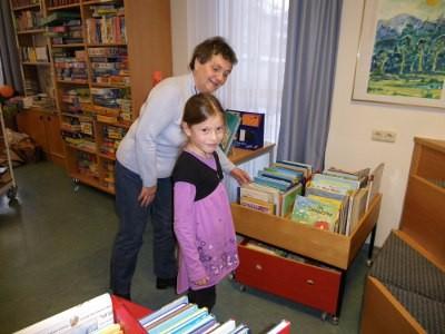 Kinderbereich mit Büchertrog:  Erwachsene und eine Kind